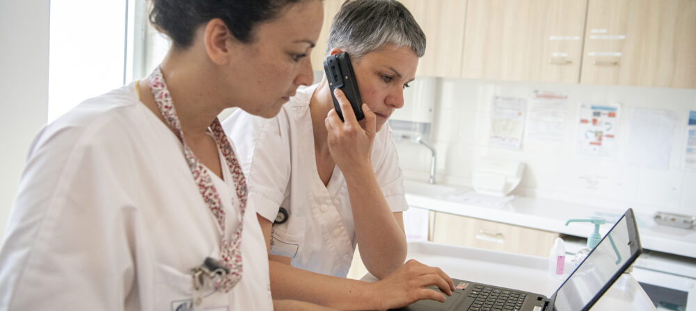 Professionnels de santé consultant un dossier patient sur ordinateur.